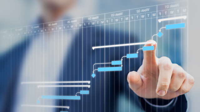 Project manager updating tasks and milestones progress planning with Gantt chart scheduling interface on a virtual screen